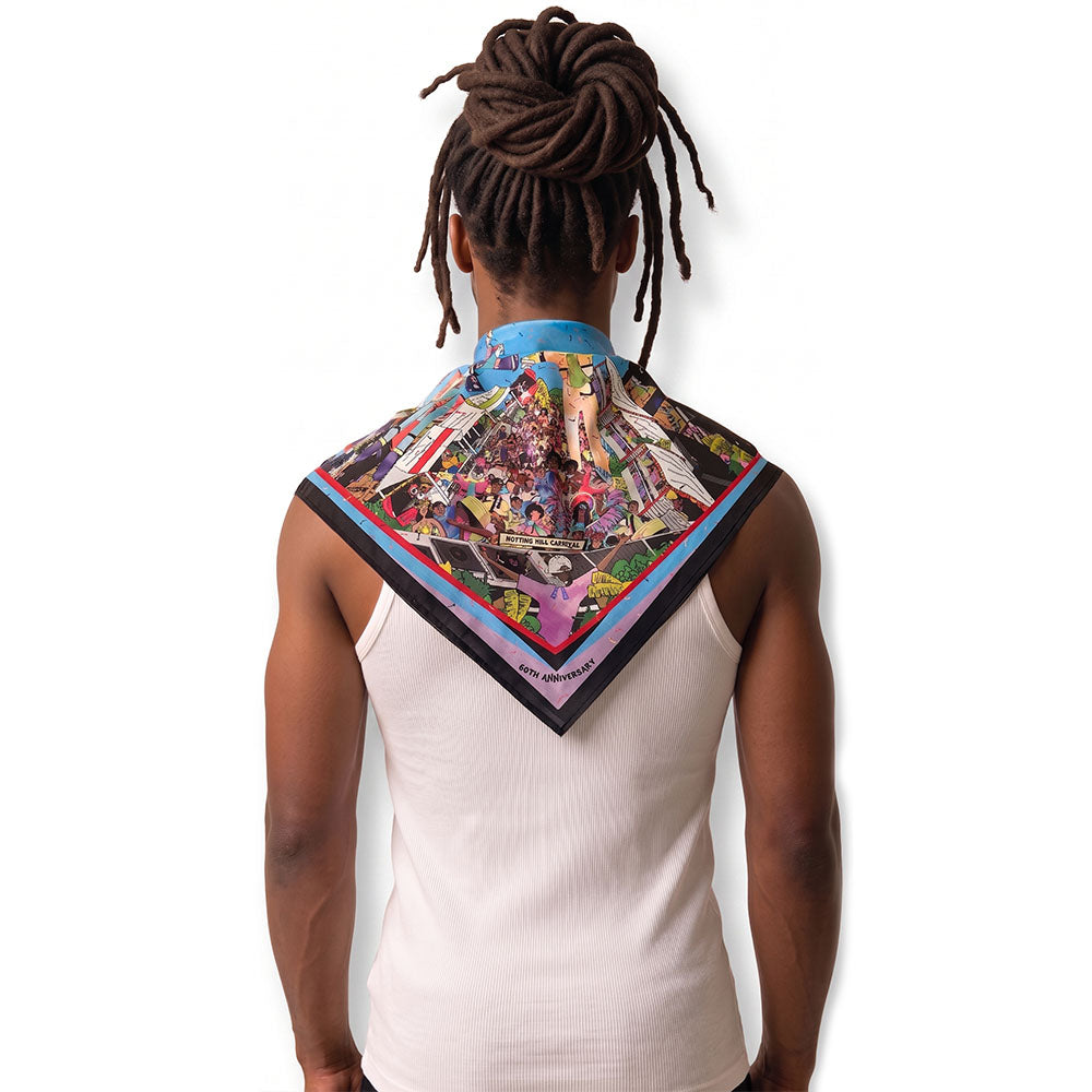 Sagaboi 60 Years on the Road silk scarf worn around the neck, featuring the Notting Hill Carnival anniversary artwork.